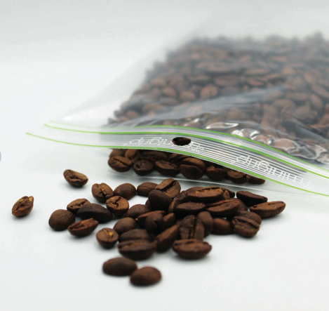 Sachets plastiques transparents mi ouvert qui contient des grains de café qui sert de sachet anti-humidité au produit