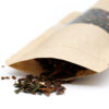 Image d'un sachet Doypack® en papier Kraft avec une fenêtre en PET/CPP, ouvert et montrant son contenu de thé ou d'herbes séchées. Le sachet offre une protection multicouche contre l'humidité et les gaz, préservant ainsi la fraîcheur et les arômes des produits emballés.